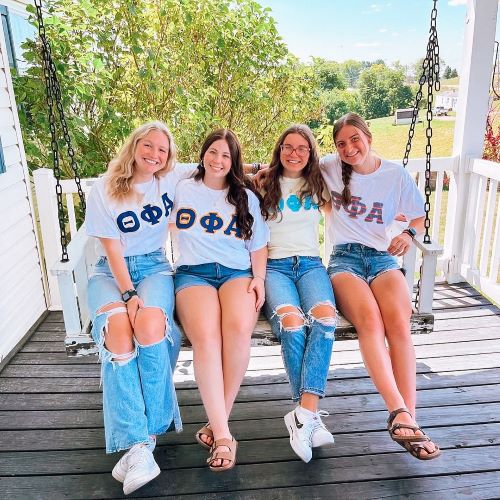 4 members sitting on porch swing